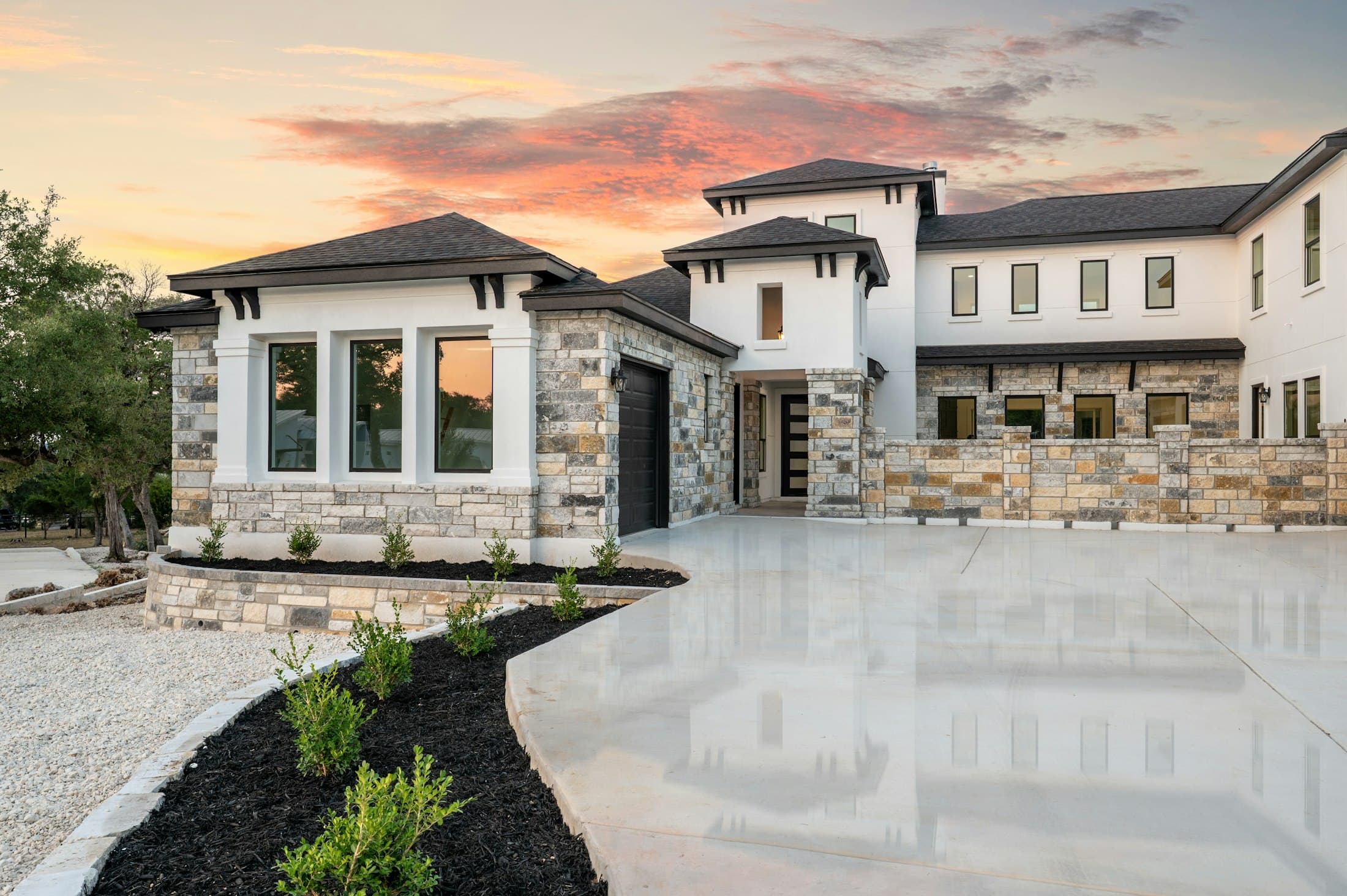 Luxury stone home with a newly paved driveway
