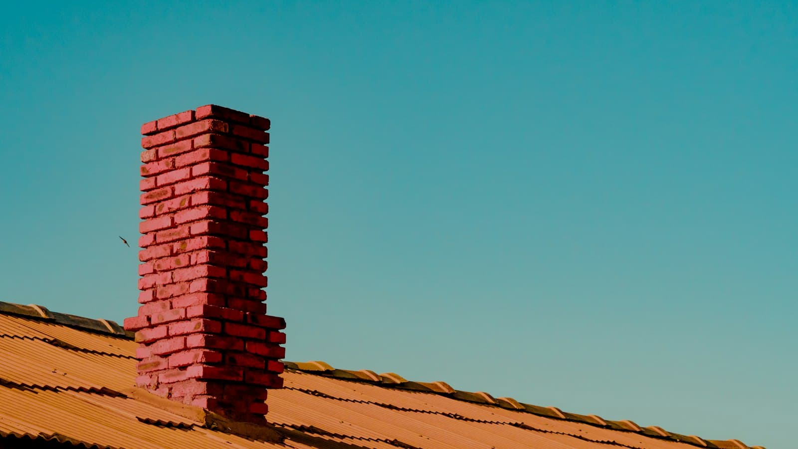 Red brick chimney against a blue sky