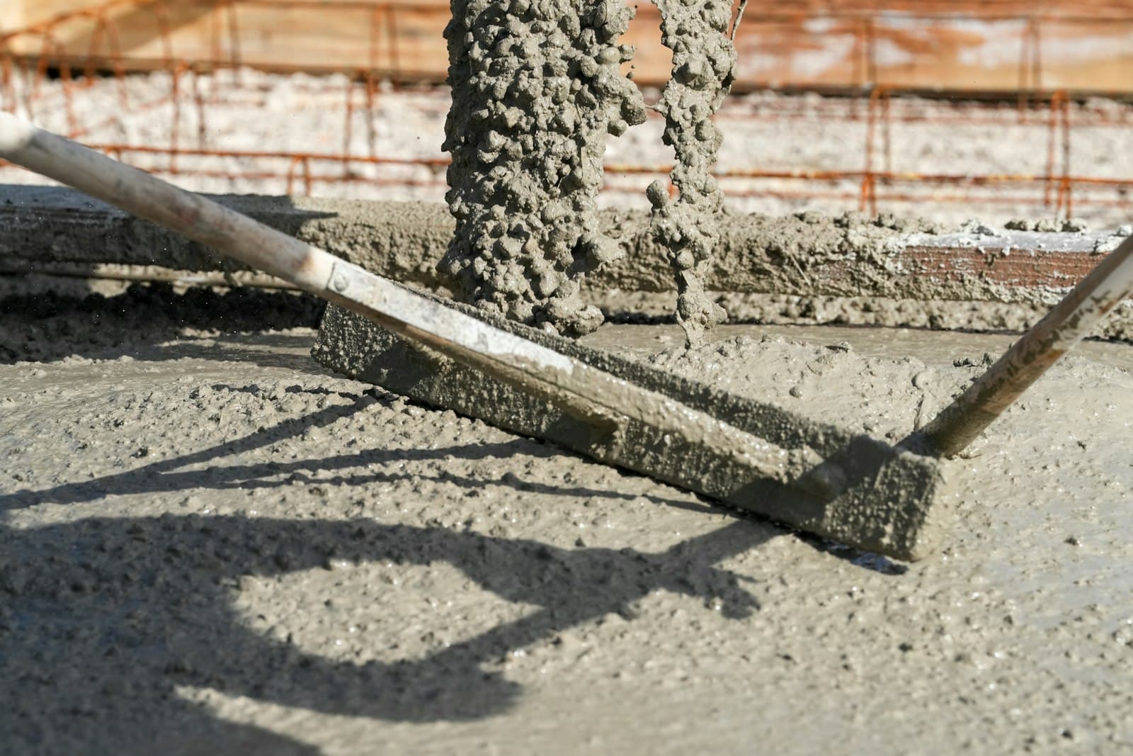 Fresh concrete being leveled with a screed