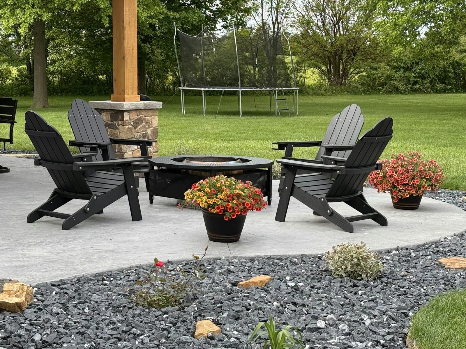 Backyard patio with adirondack chairs and a fire pit